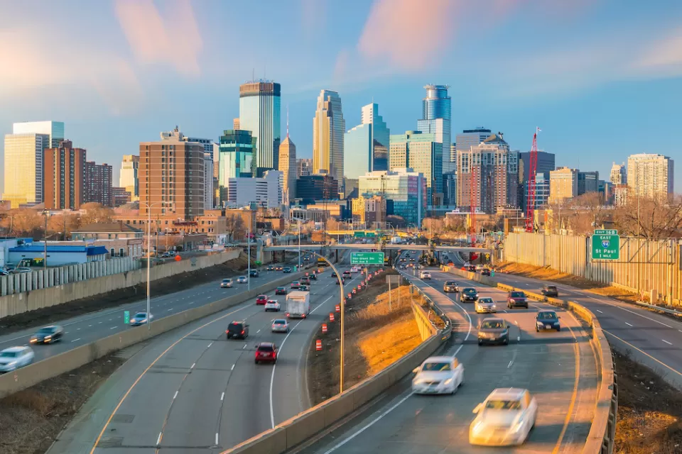 View of Minneapolis freeway with downtown skyline in background with light traffic at golden hour.